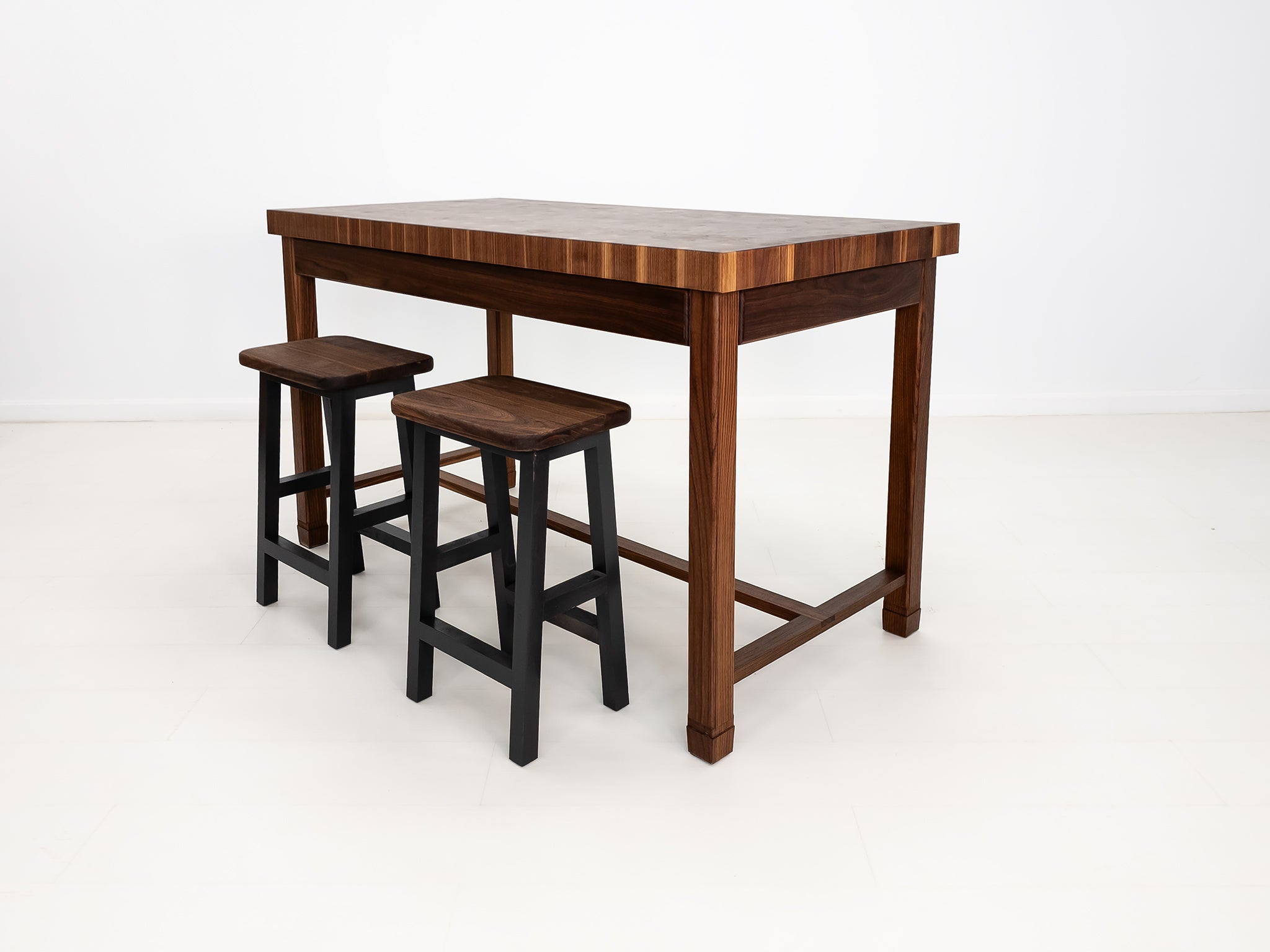 CAMI butcher block island in solid walnut with end-grain top and stretcher base.