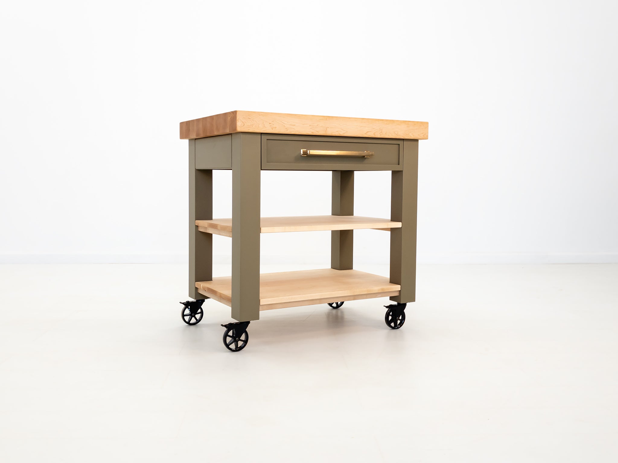 Rolling butcher block cart with inset drawer and locking casters.