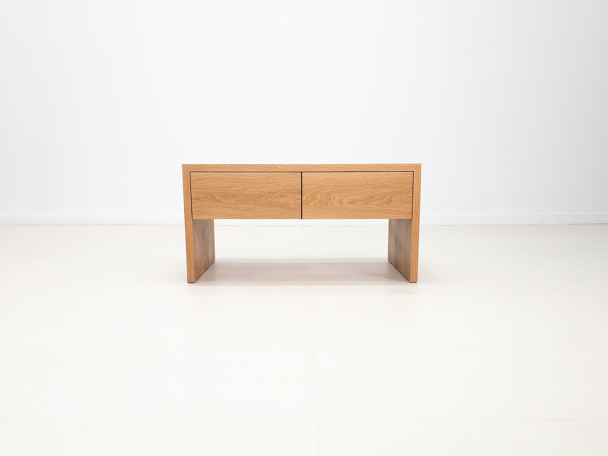 DREW coffee table in white oak with waterfall edge and soft-close drawers.
