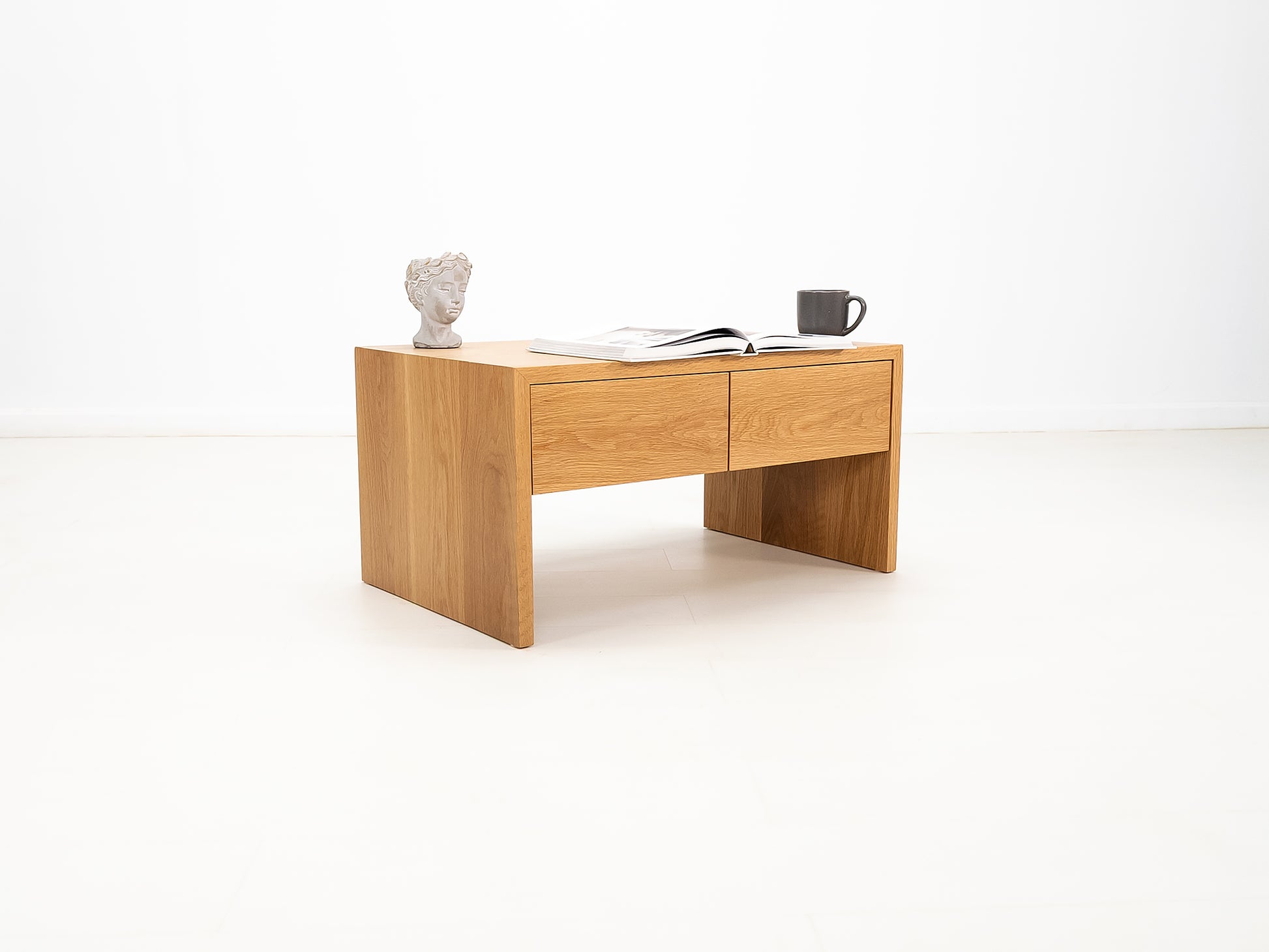 DREW coffee table in white oak with waterfall edge and soft-close drawers.
