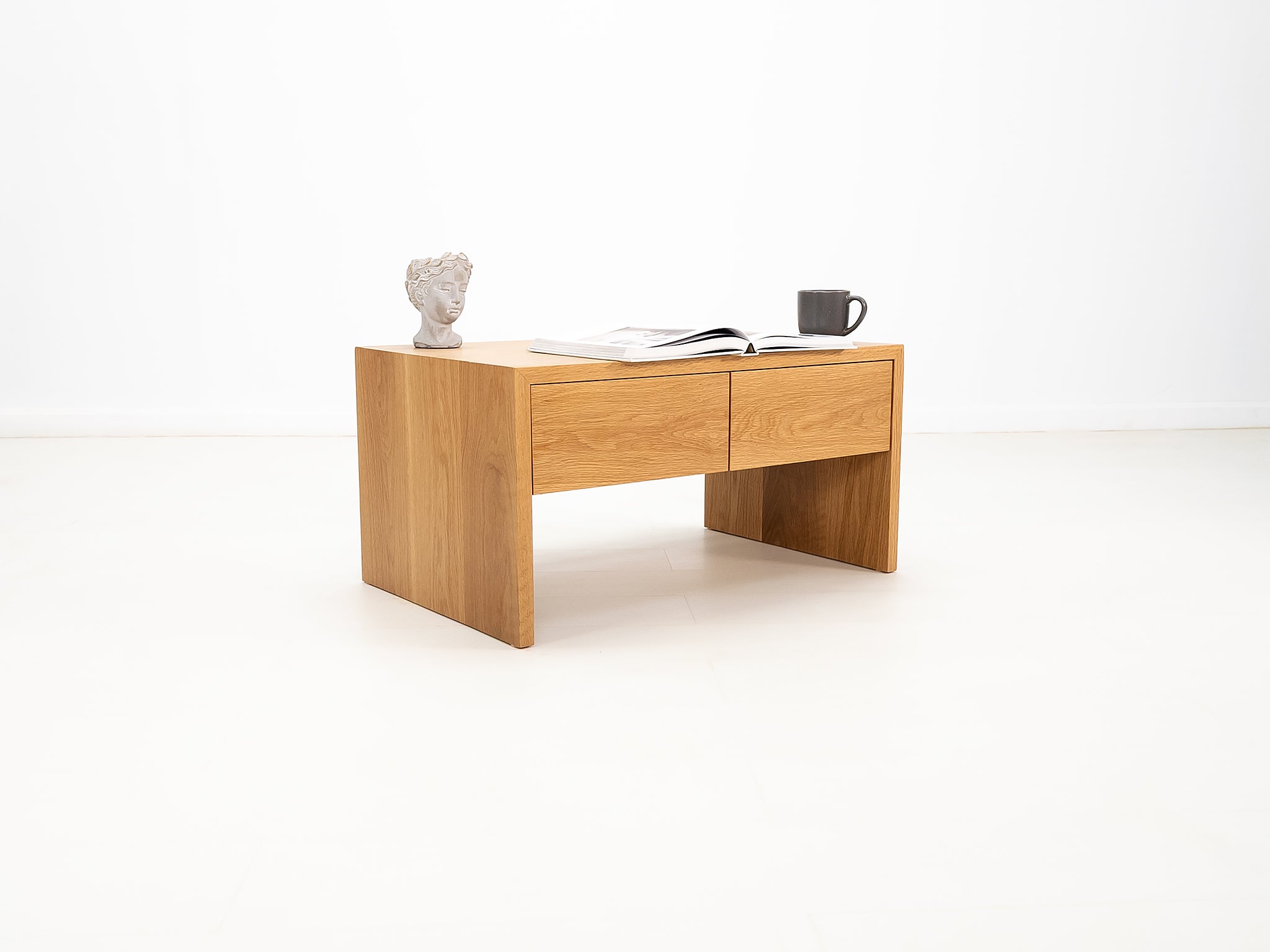 DREW coffee table in white oak with waterfall edge and soft-close drawers.