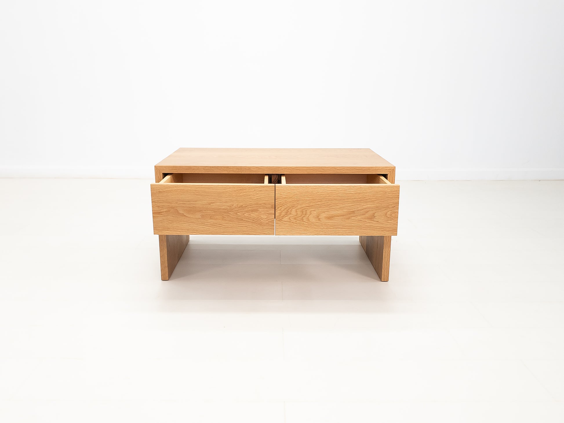 DREW coffee table in white oak with waterfall edge and soft-close drawers.