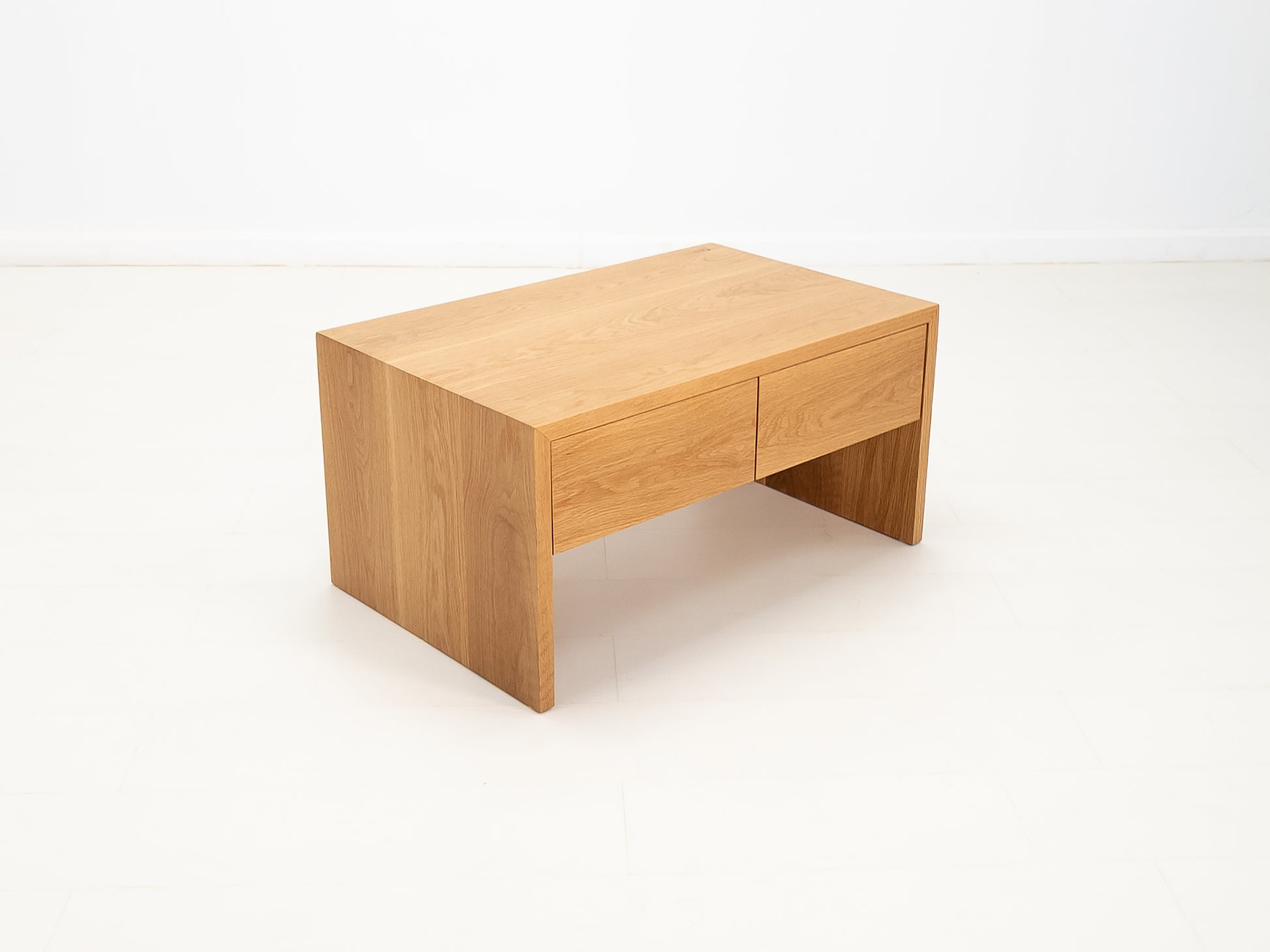 DREW coffee table in white oak with waterfall edge and soft-close drawers.