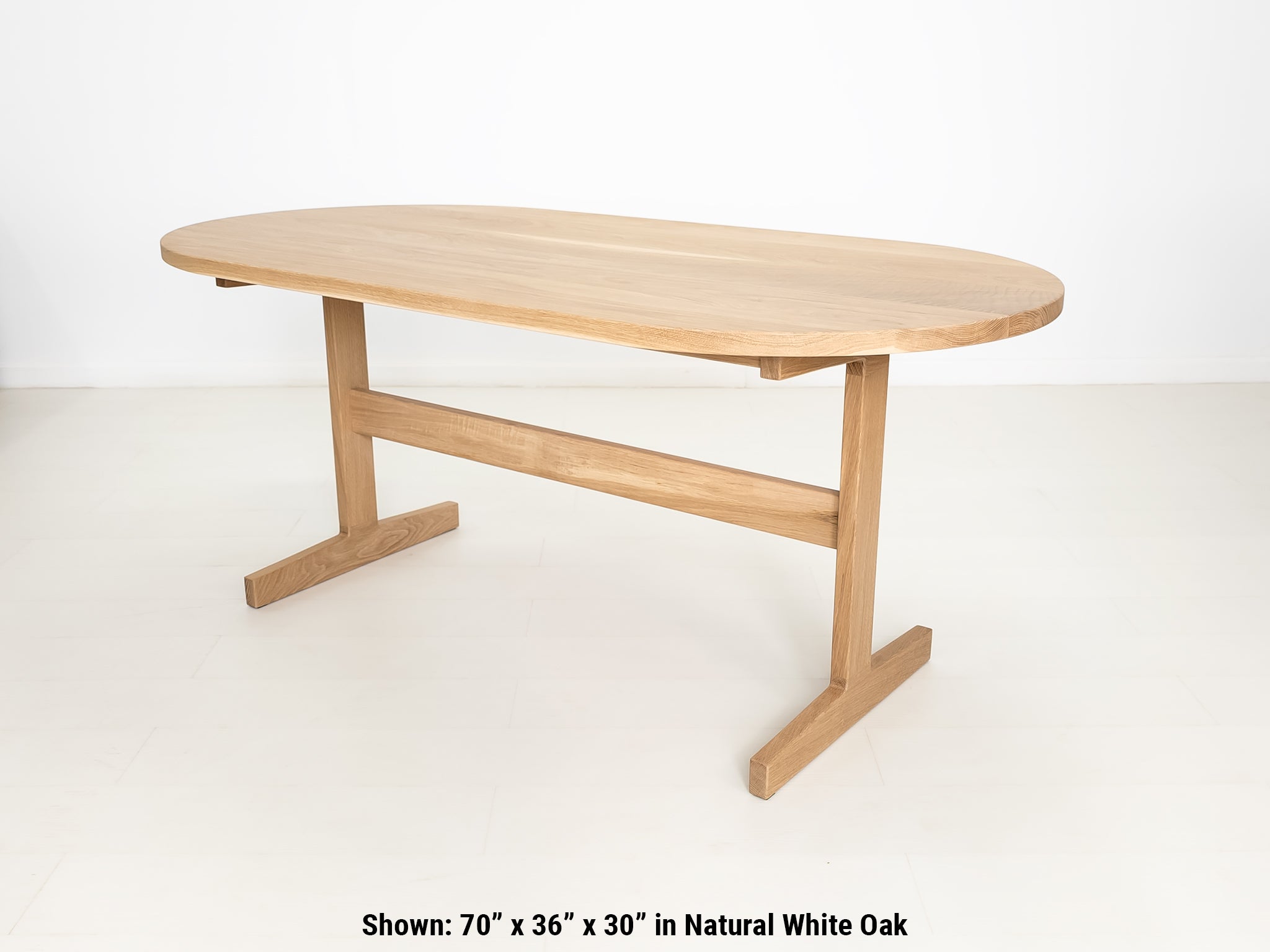 Custom wood dining table with clean lines and trestle base, shown in natural white oak.