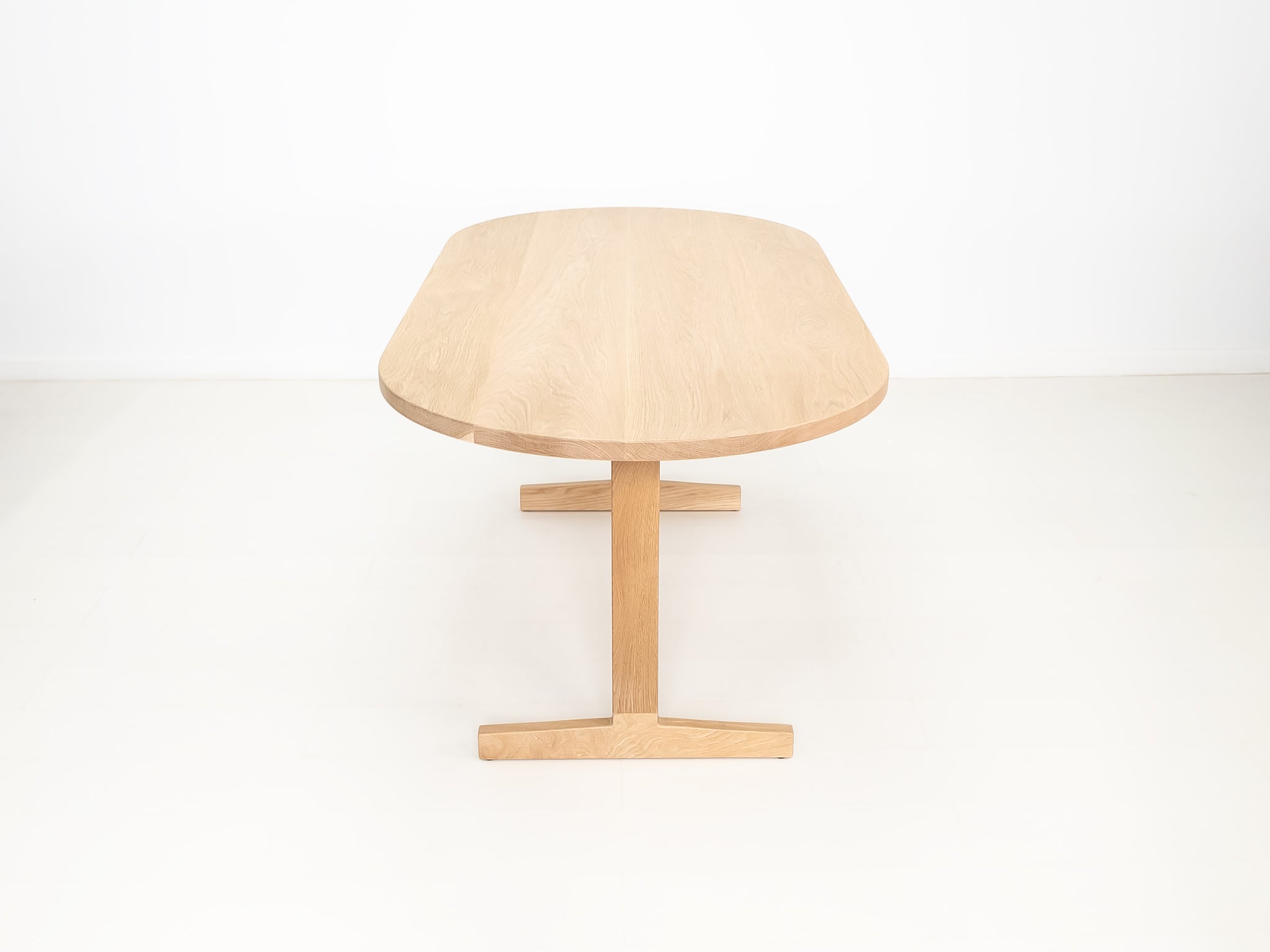 BANQ dining table in natural white oak with trestle base.