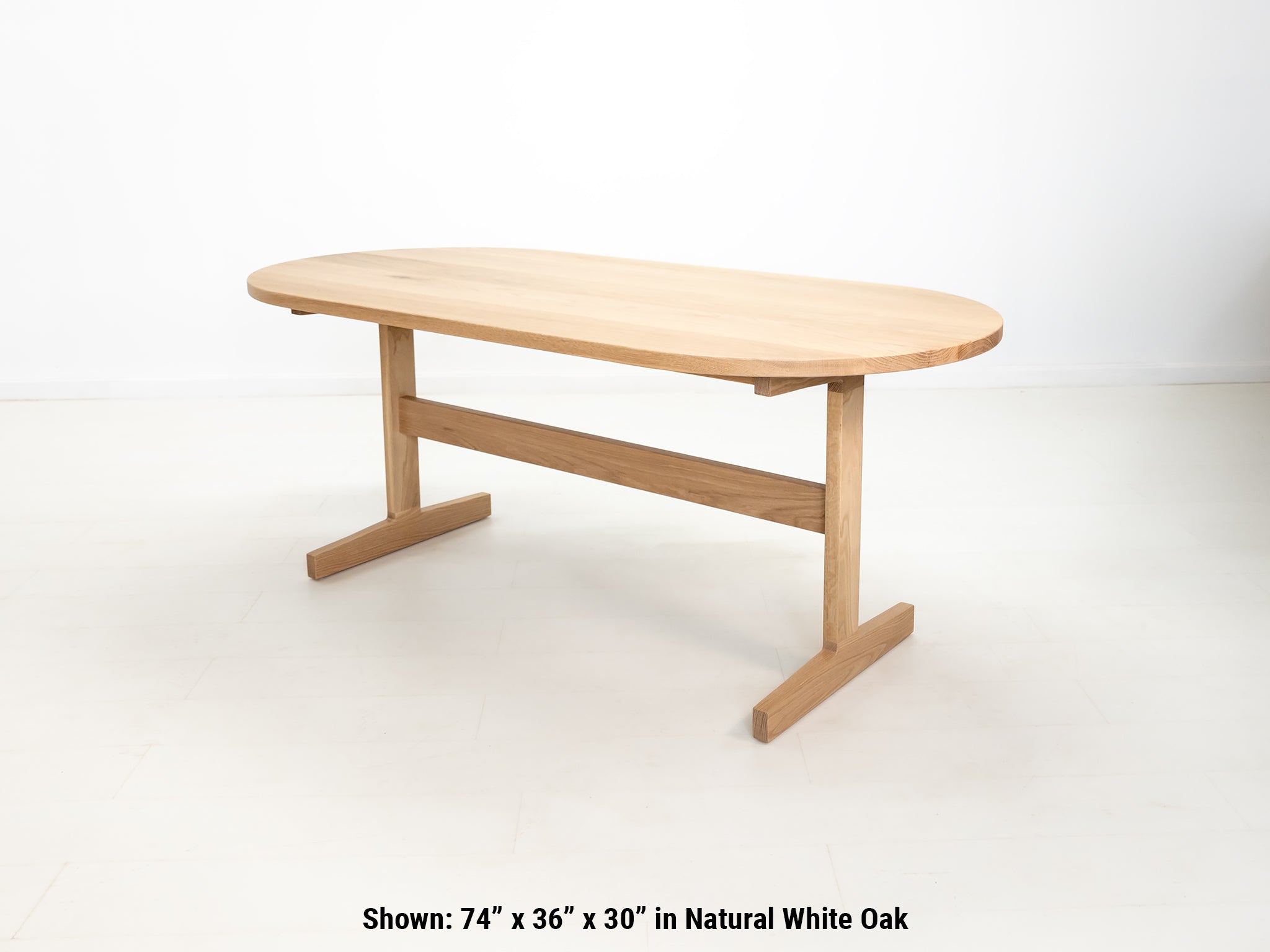 Custom wood dining table with clean lines and trestle base, shown in natural white oak.