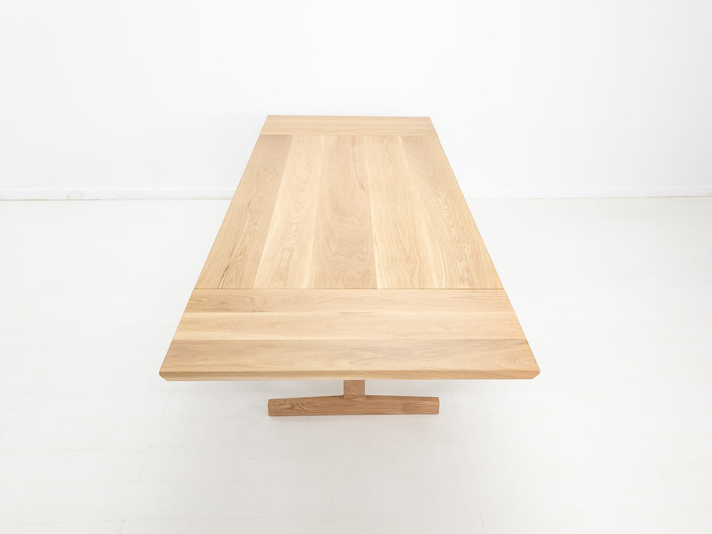 BRIT trestle dining table in natural white oak, shown with beveled edge top.