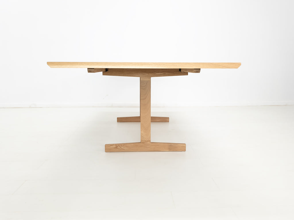 BRIT trestle dining table in natural white oak, shown with beveled edge top.
