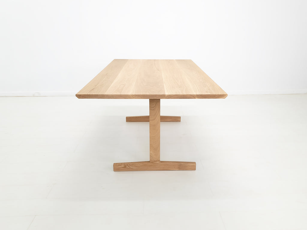 BRIT trestle dining table in natural white oak, shown with beveled edge top.