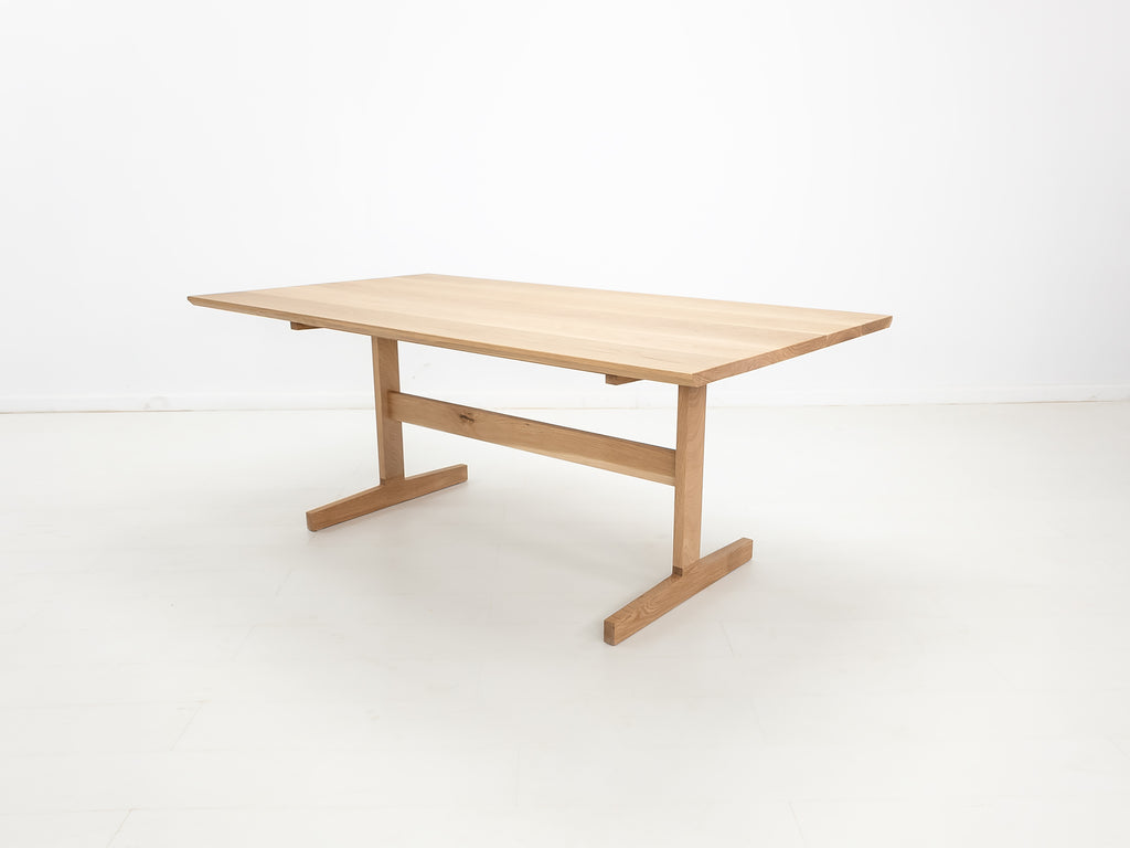BRIT trestle dining table in natural white oak, shown with beveled edge top.