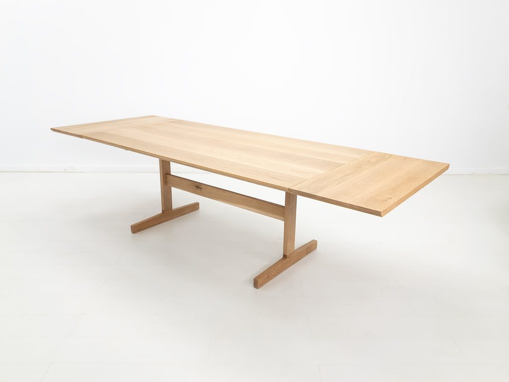BRIT trestle dining table in natural white oak, shown with beveled edge top.