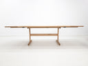 BRIT trestle dining table in natural white oak, shown with beveled edge top and clear matte finish.