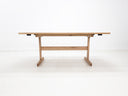 BRIT trestle dining table in natural white oak, shown with beveled edge top and clear matte finish.
