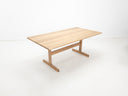 BRIT trestle dining table in natural white oak, shown with beveled edge top and clear matte finish.