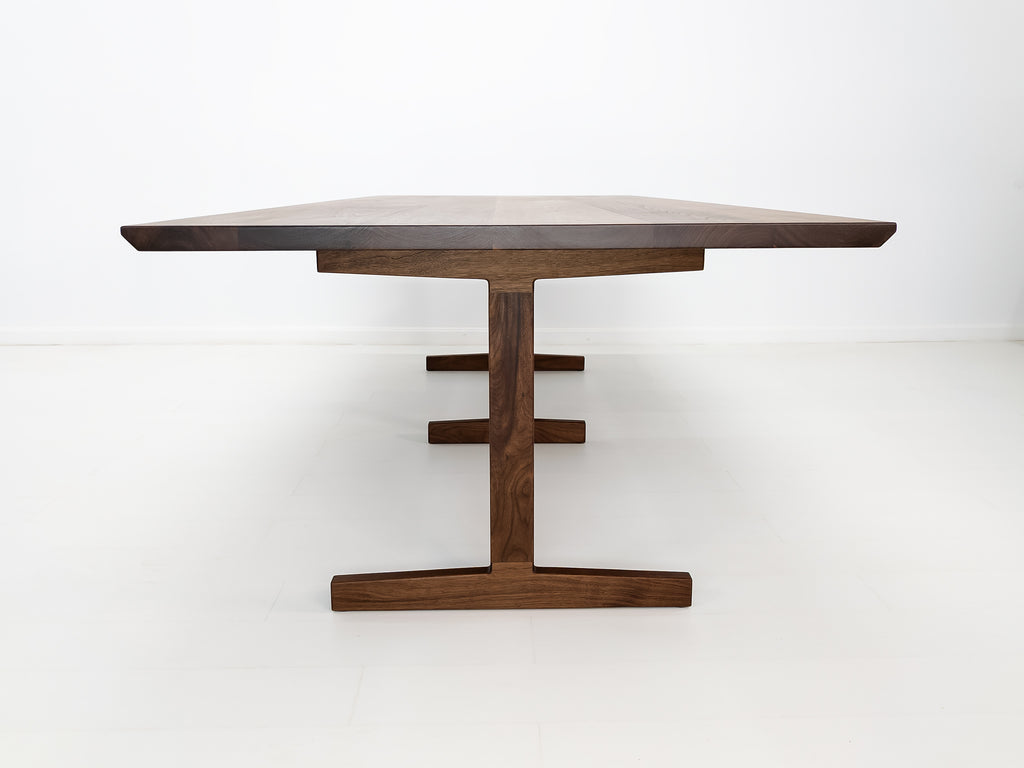 View of oiled walnut BRIT table in white studio setting.