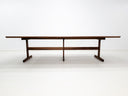 BRIT trestle dining table in oiled walnut, shown with beveled edge top and hardwax oil finish.