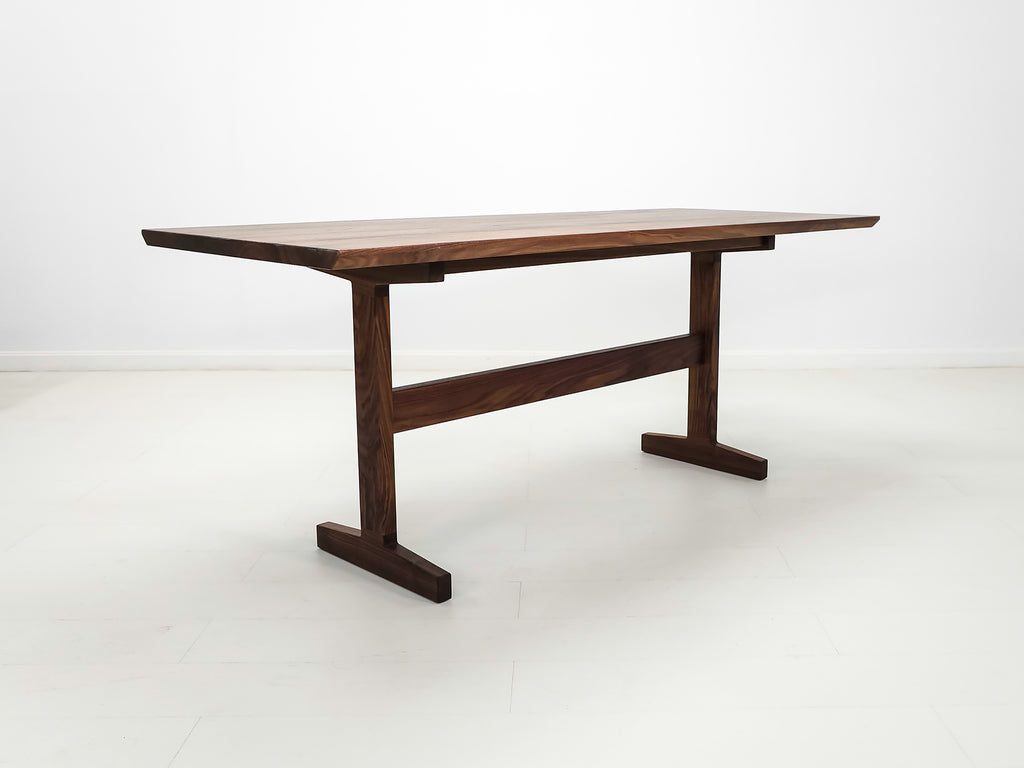 Close-up of beveled walnut tabletop with smooth, hand-finished edge.