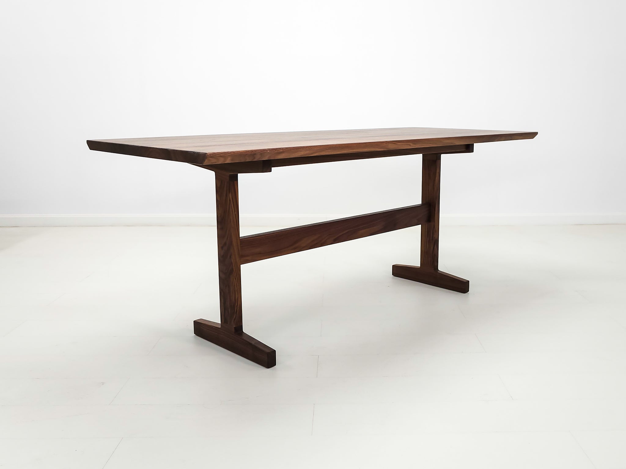 Close-up of beveled walnut tabletop with smooth, hand-finished edge.