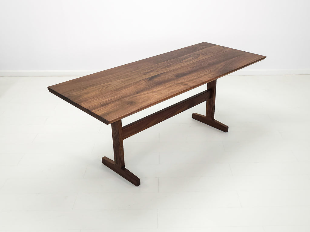 Close-up of beveled walnut tabletop with smooth, hand-finished edge.
