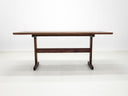 Walnut trestle table with smooth, hand-finished edge.