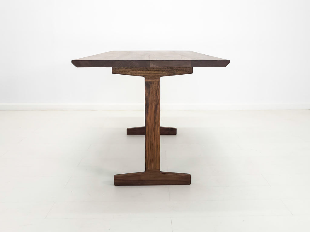 Close-up of beveled walnut tabletop with smooth, hand-finished edge.