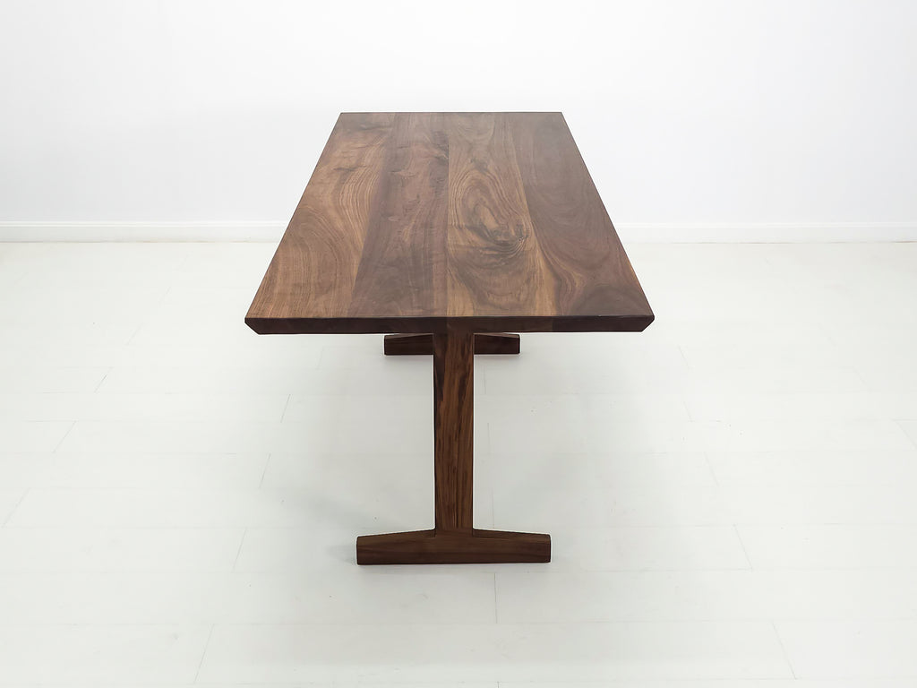 Close-up of beveled walnut tabletop with smooth, hand-finished edge.
