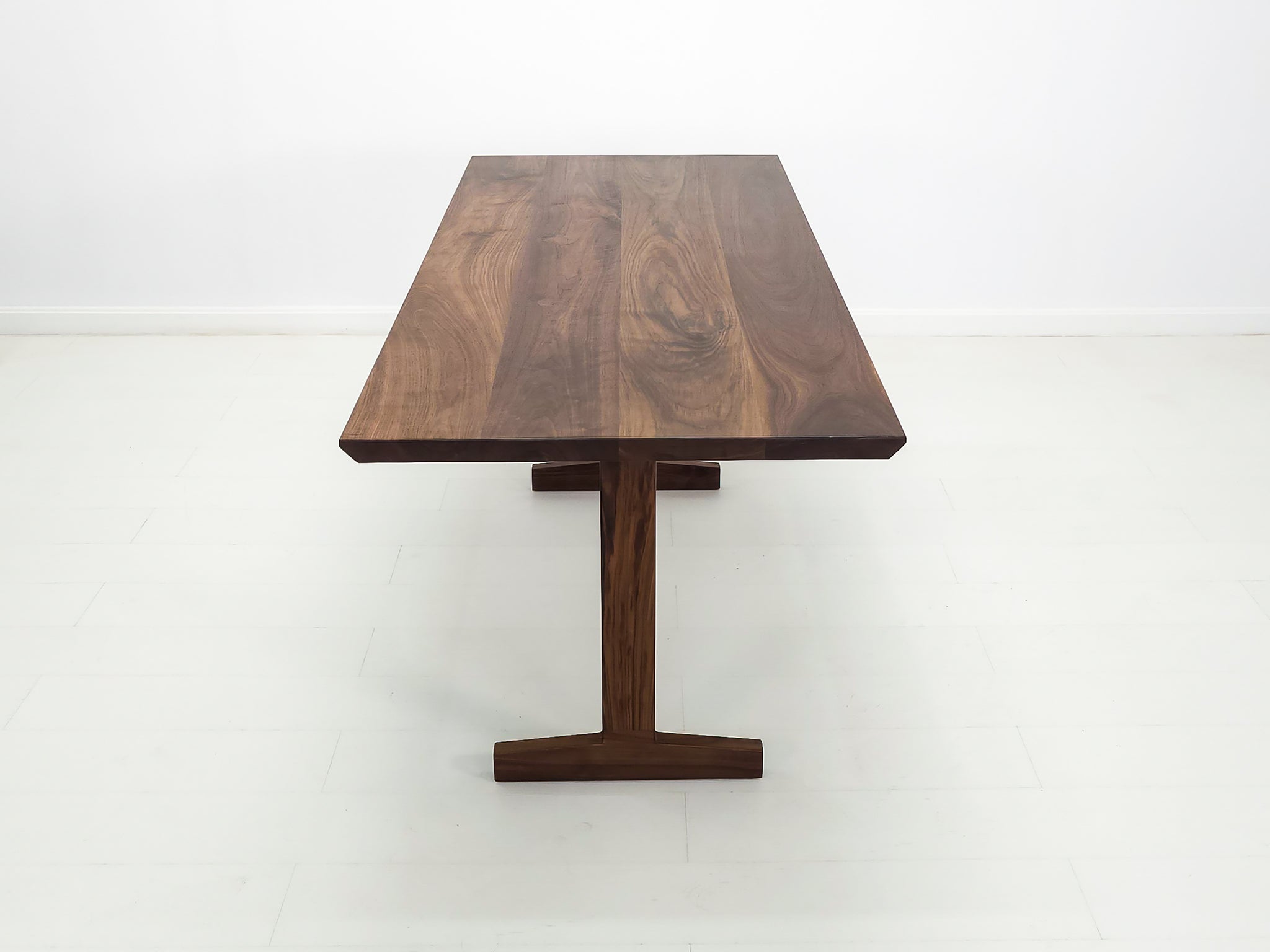 Close-up of beveled walnut tabletop with smooth, hand-finished edge.