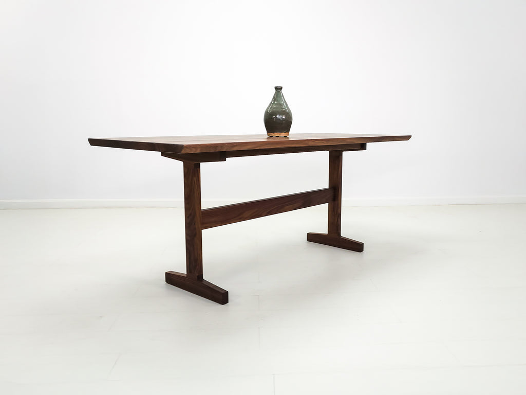 Close-up of beveled walnut tabletop with smooth, hand-finished edge.