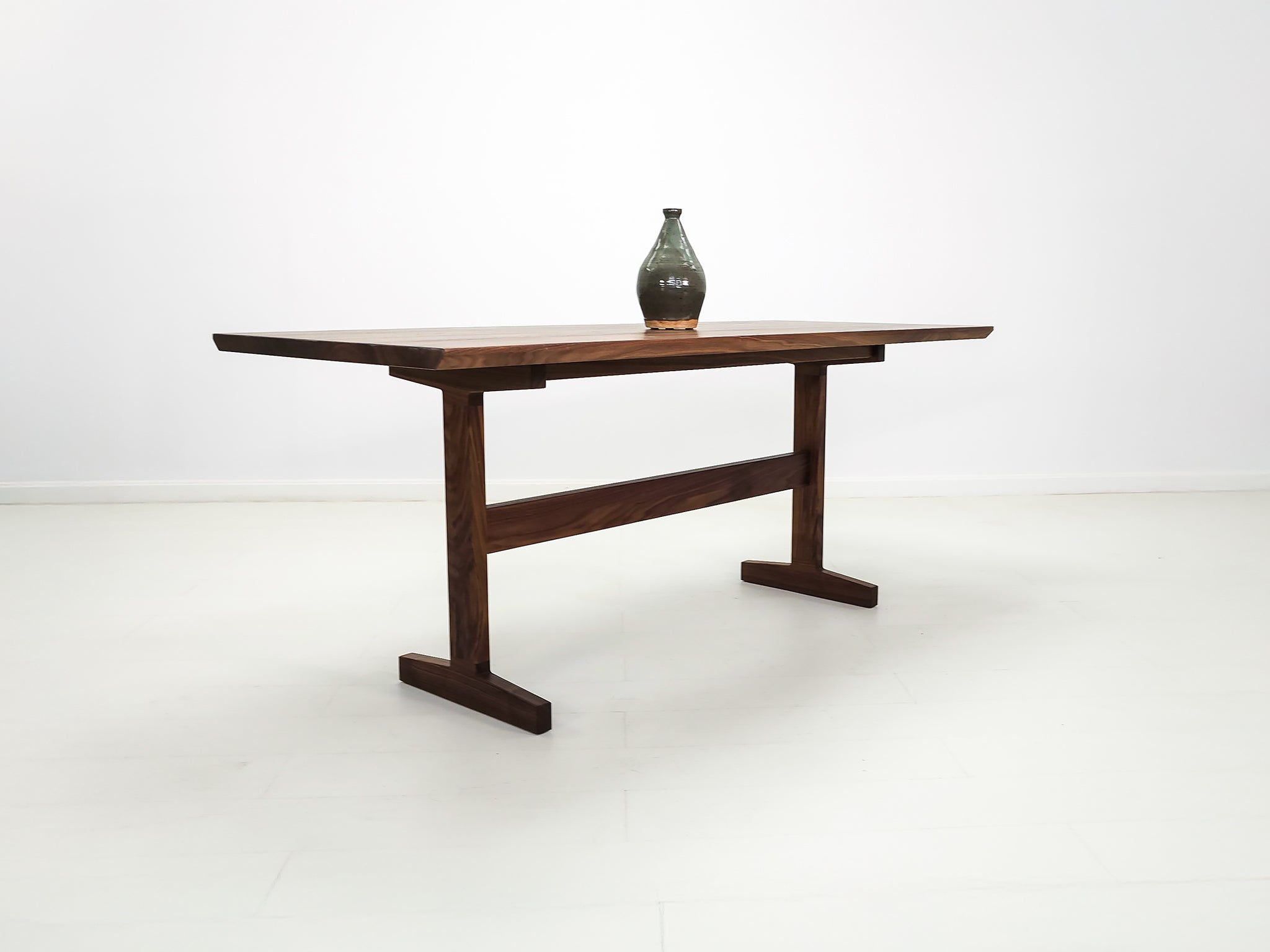 Close-up of beveled walnut tabletop with smooth, hand-finished edge.