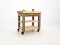 Rolling butcher block cart with inset drawer and locking casters.