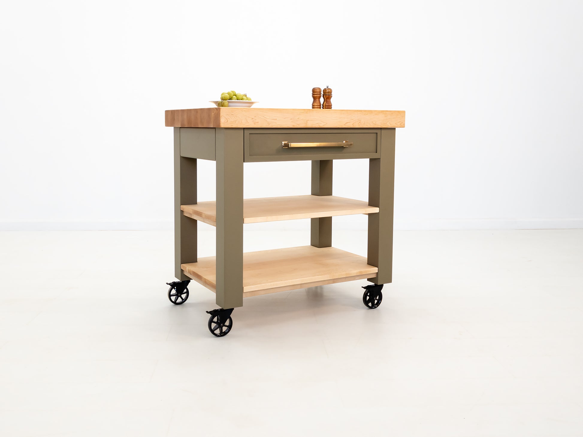Rolling butcher block cart with inset drawer and locking casters.