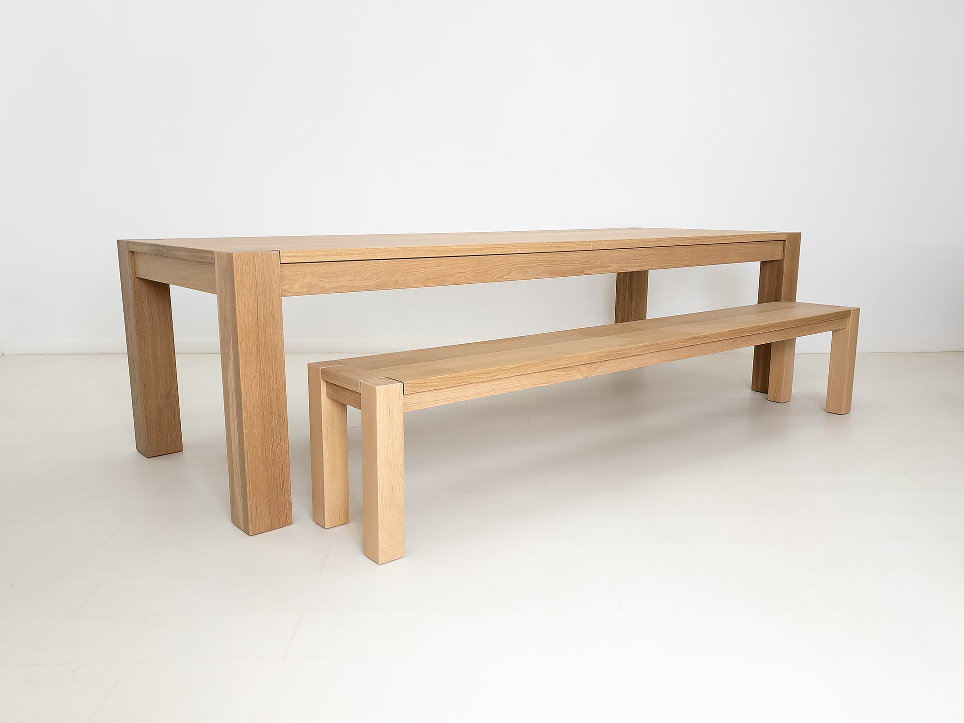 JAQI dining table in solid white oak with breadboard ends, square legs and a coordinating tuck-in bench.