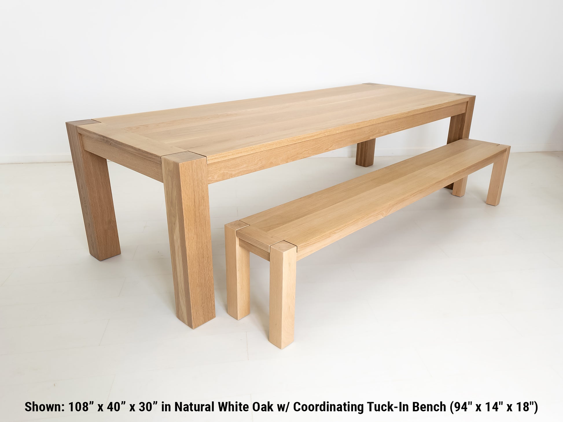 JAQI dining table in solid white oak with breadboard ends, square legs and a coordinating tuck-in bench.