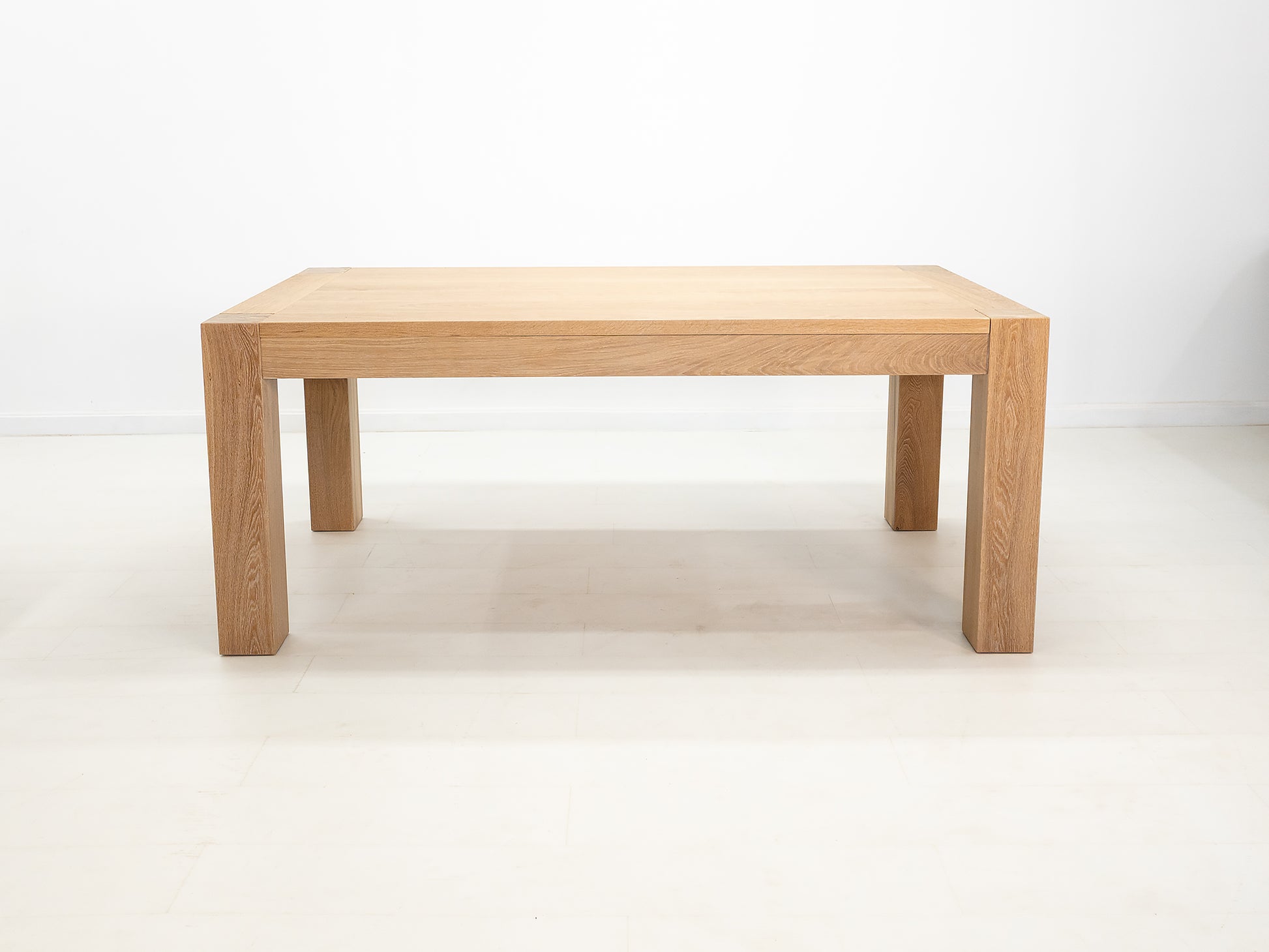 JAQI dining table in solid white oak with breadboard ends and square legs.