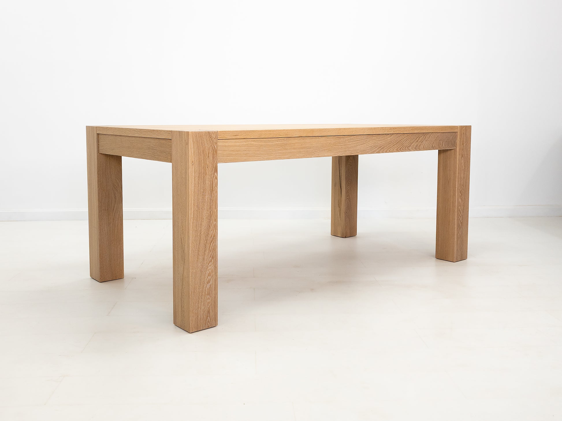 JAQI dining table in solid white oak with breadboard ends and square legs.