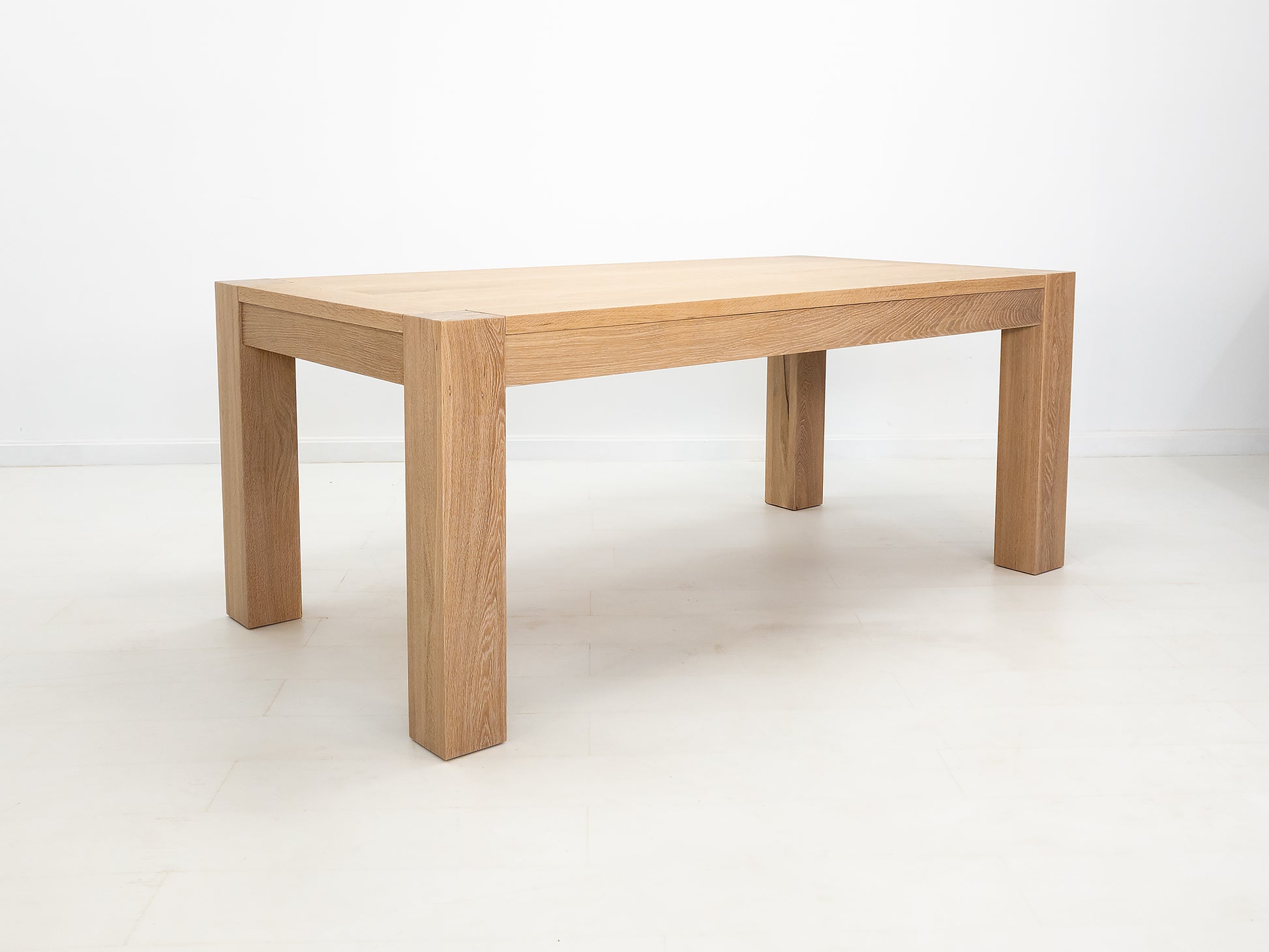JAQI dining table in solid white oak with breadboard ends and square legs.