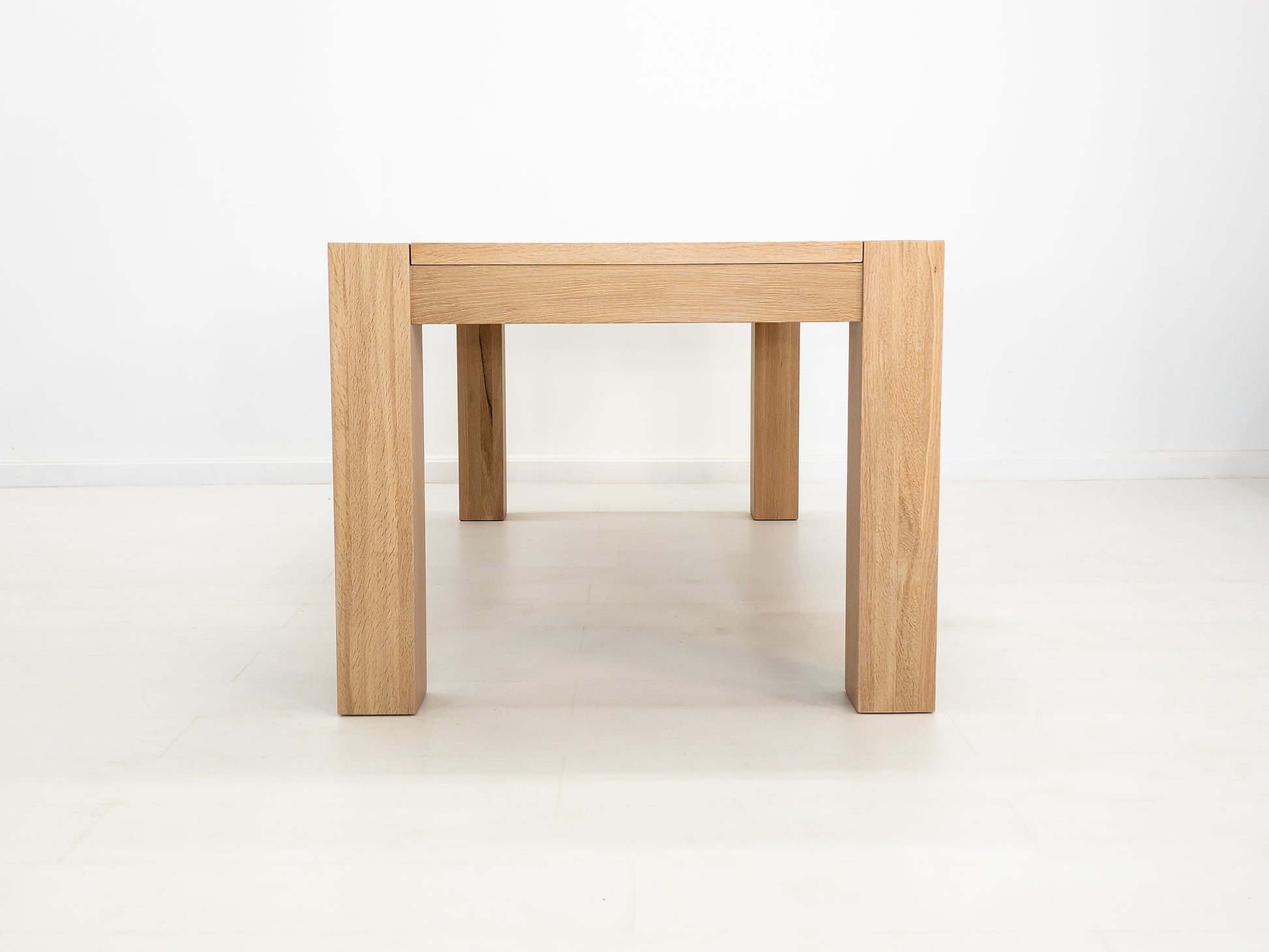 JAQI dining table in solid white oak with breadboard ends and square legs.