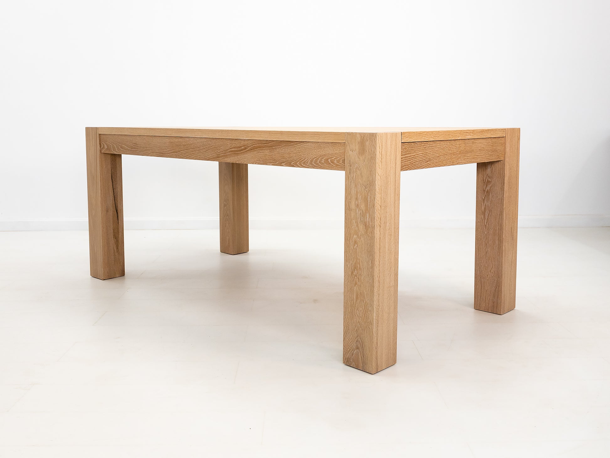 JAQI dining table in solid white oak with breadboard ends and square legs.