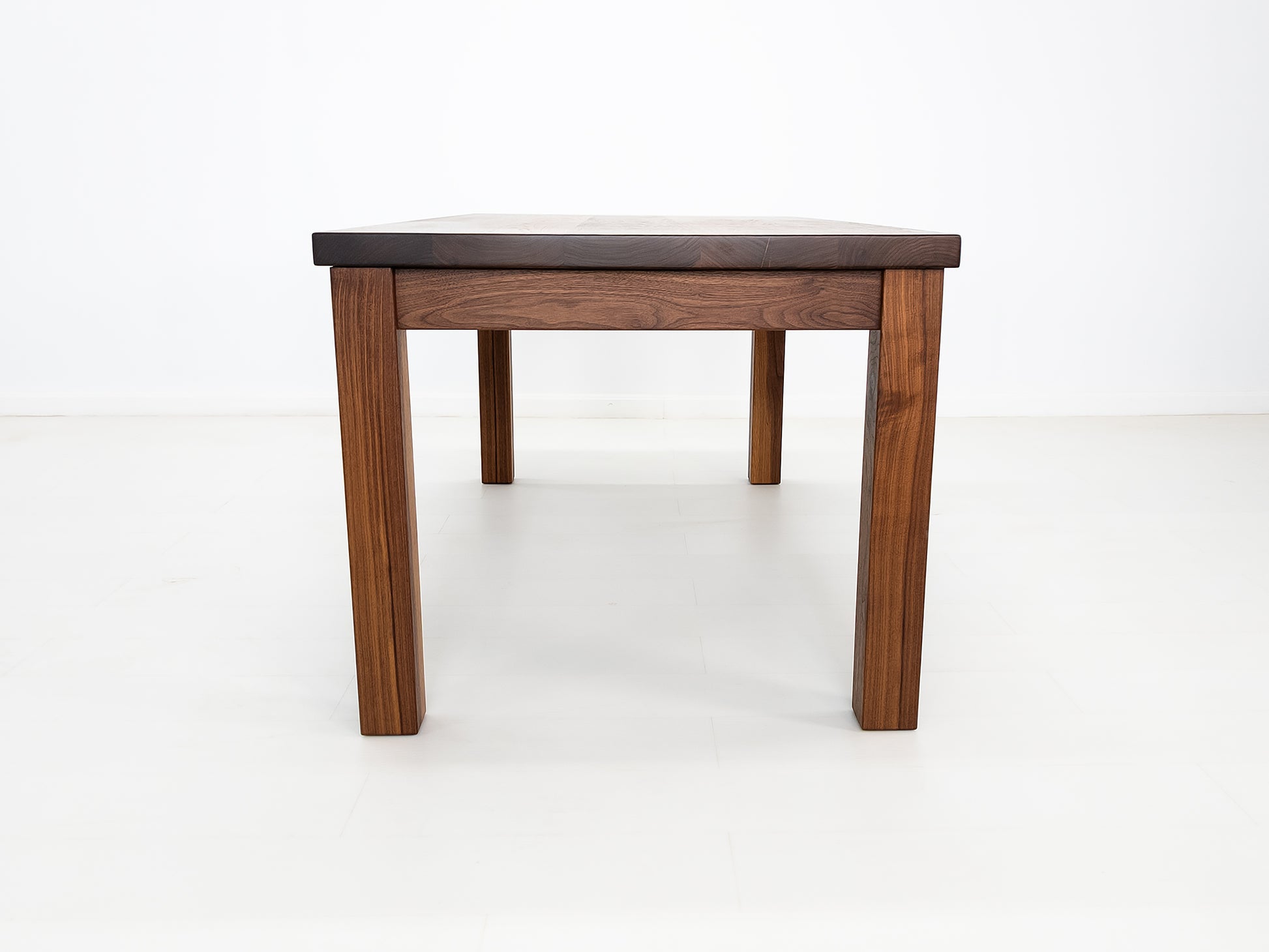 JONA dining table in oiled walnut with square legs.