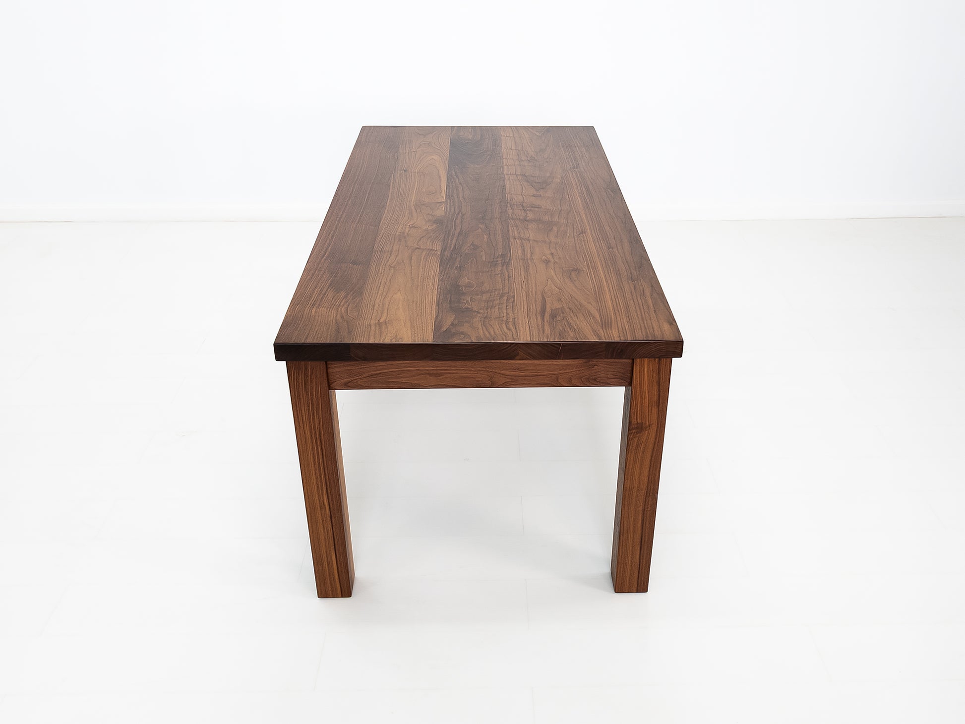 JONA dining table in oiled walnut with square legs.