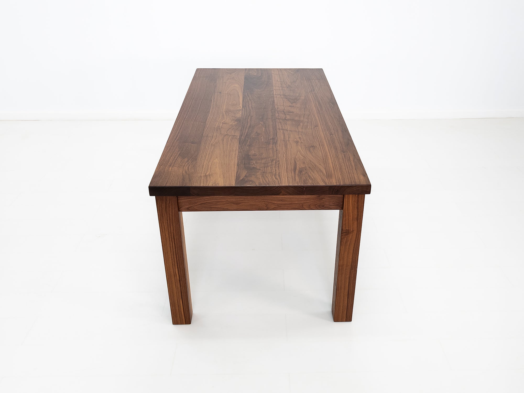 JONA dining table in oiled walnut with square legs.