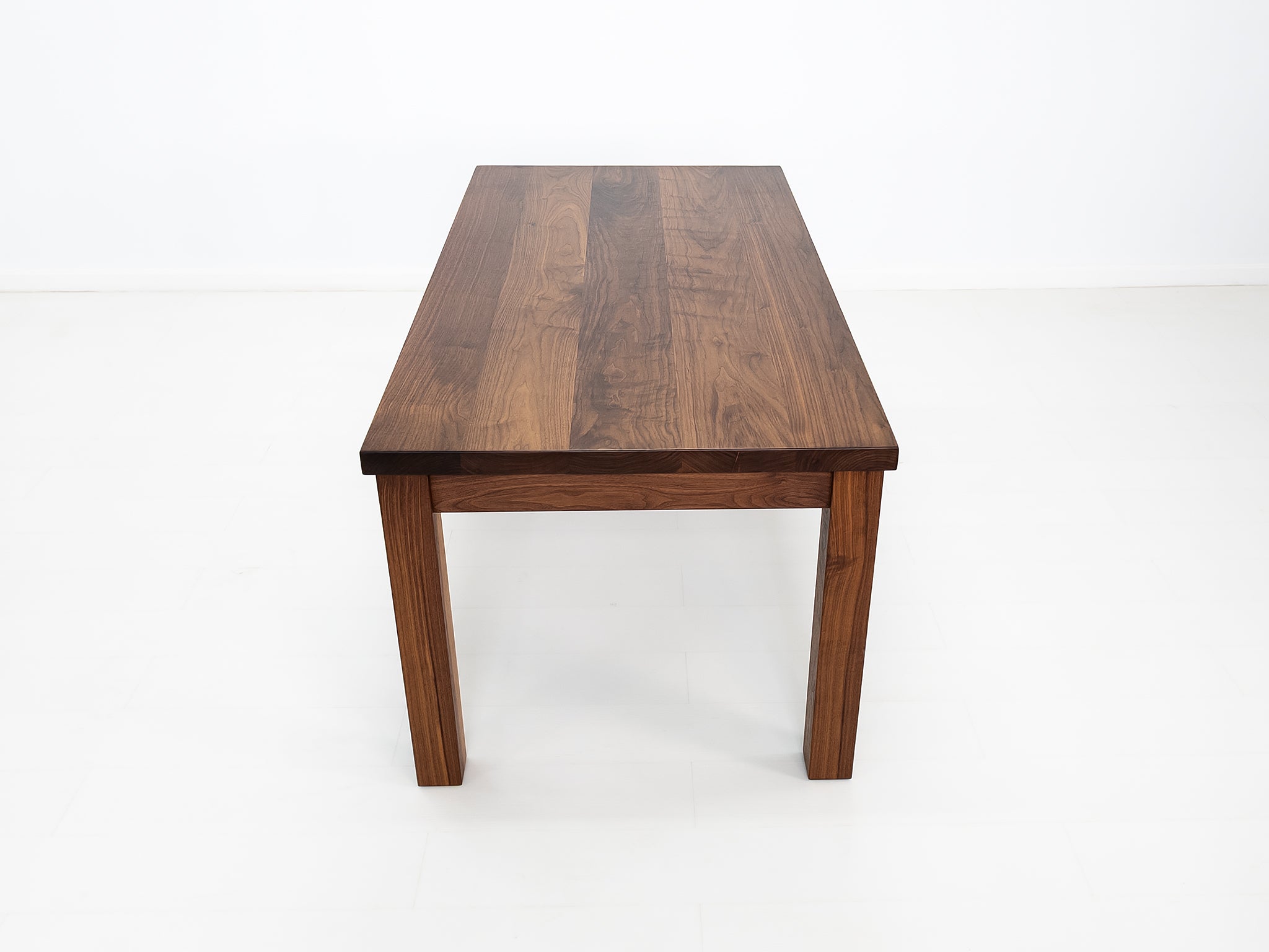 JONA dining table in oiled walnut with square legs.
