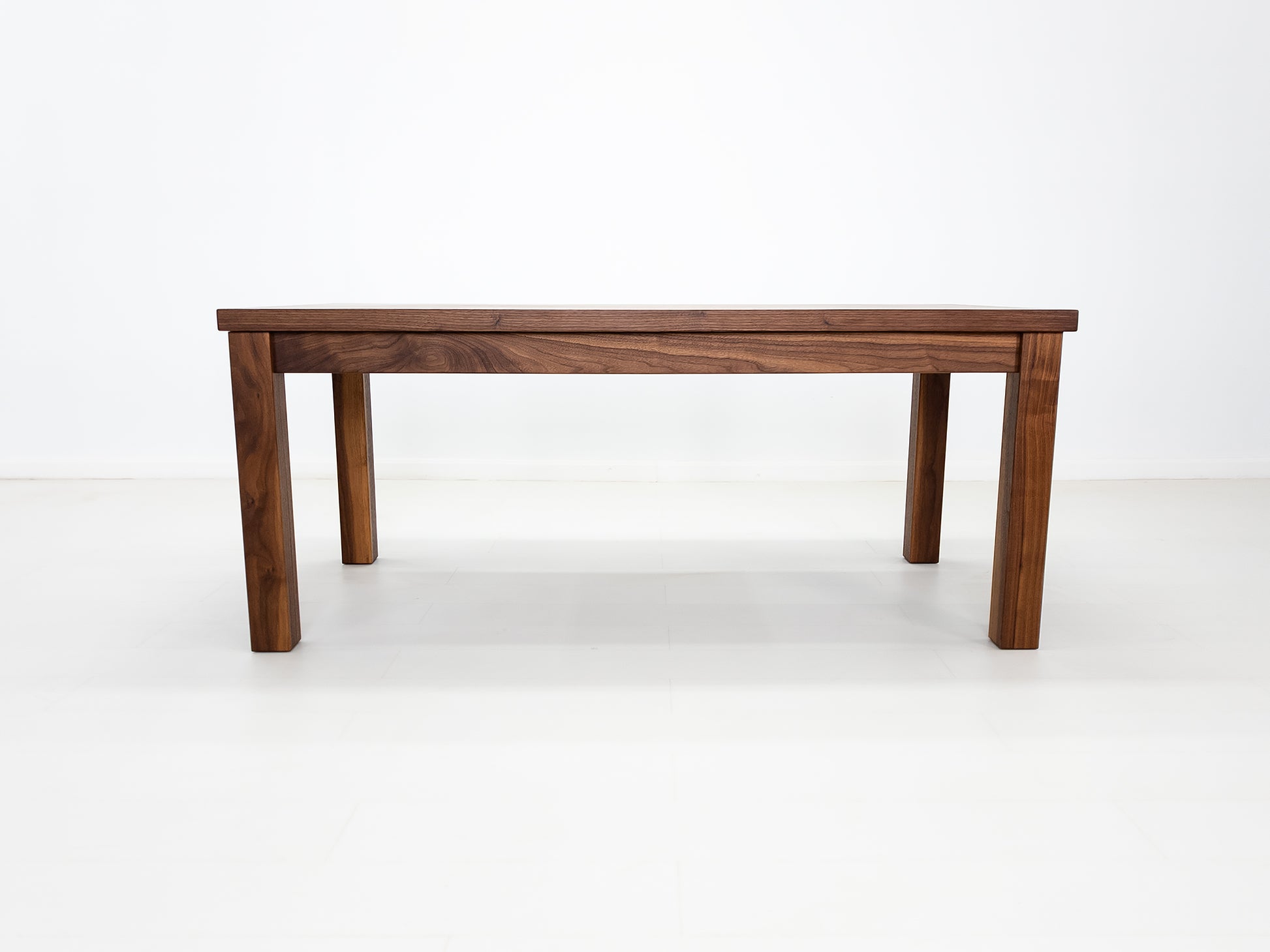 JONA dining table in oiled walnut with square legs.