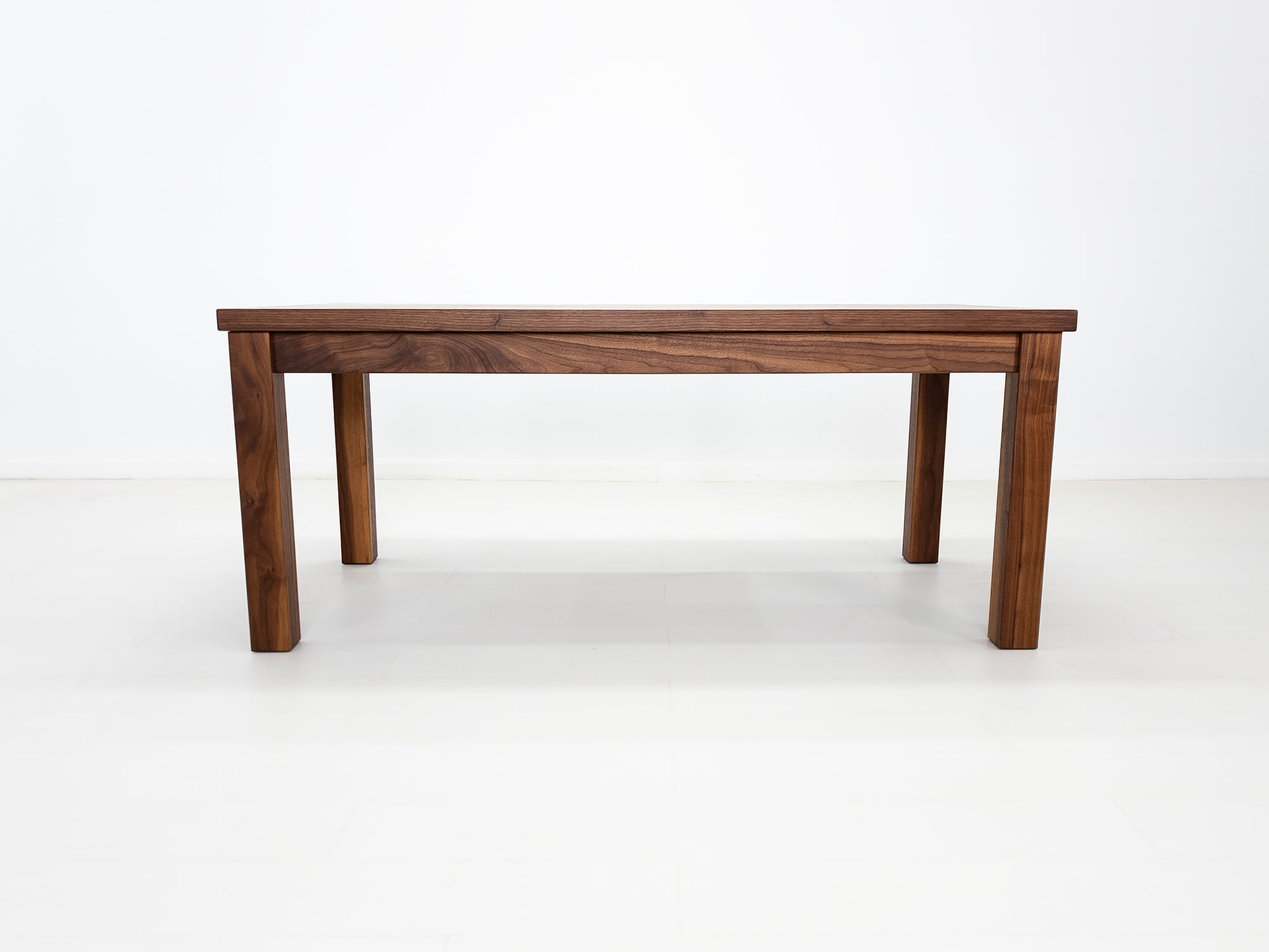 JONA dining table in oiled walnut with square legs.