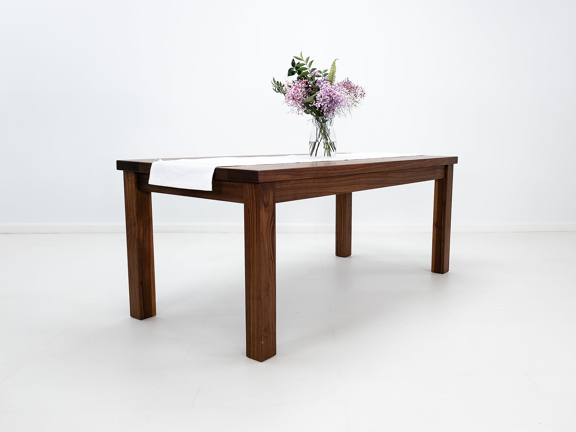 JONA dining table in oiled walnut with square legs.