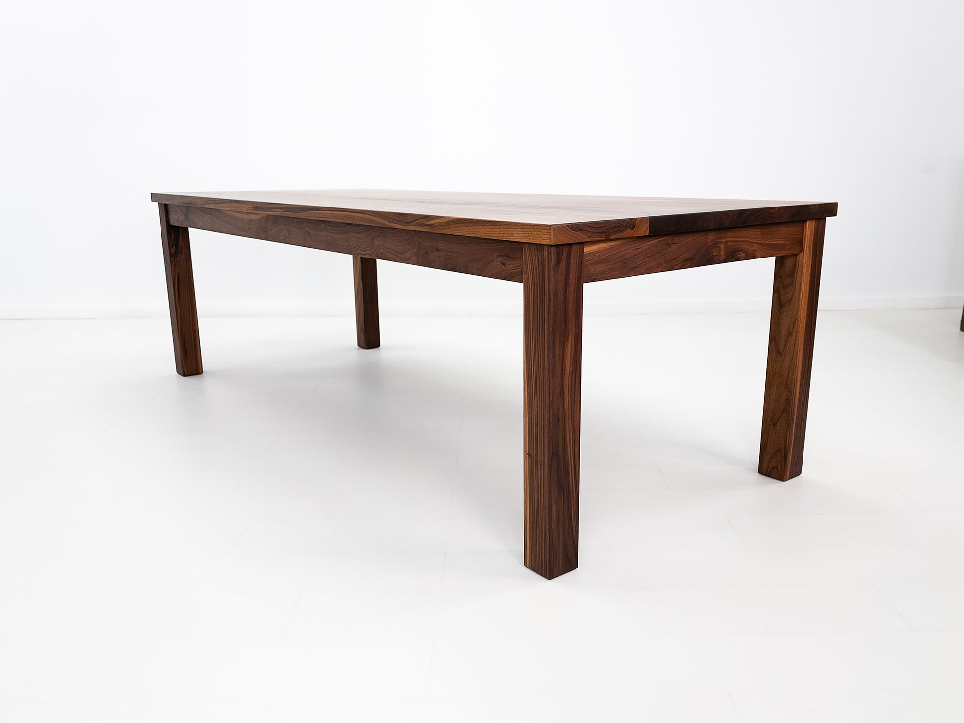 JONA dining table in oiled walnut with square legs.