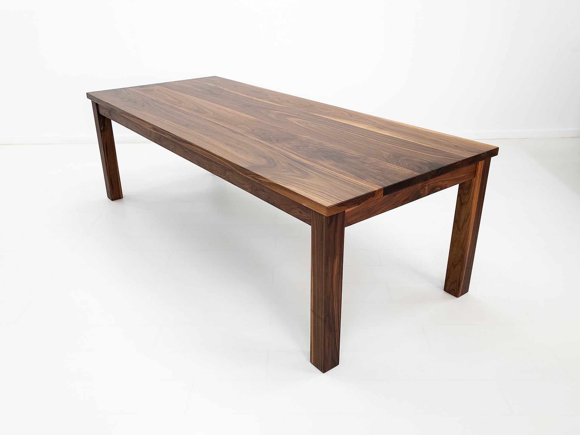 JONA dining table in oiled walnut with square legs.