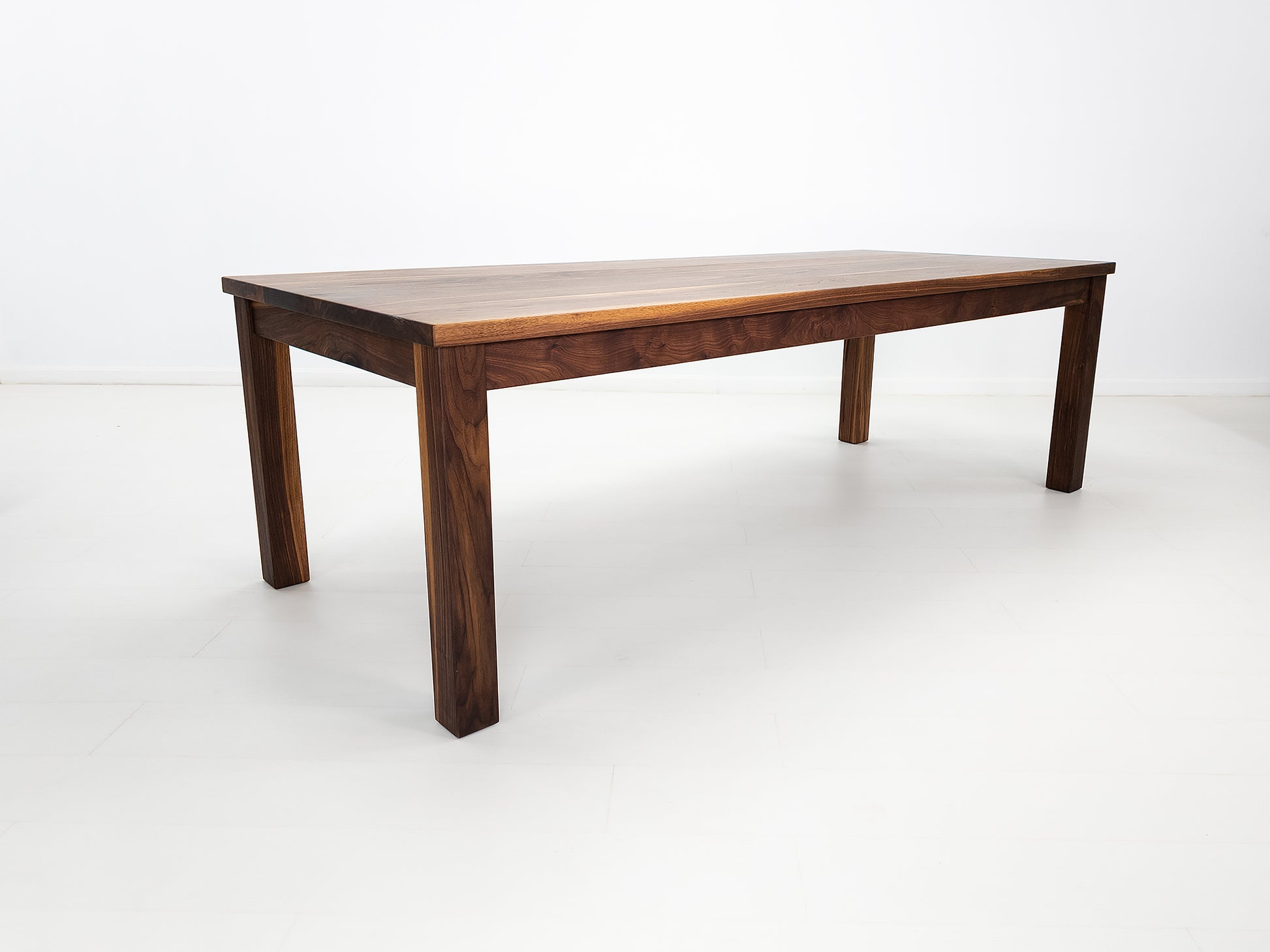 JONA dining table in oiled walnut with square legs.