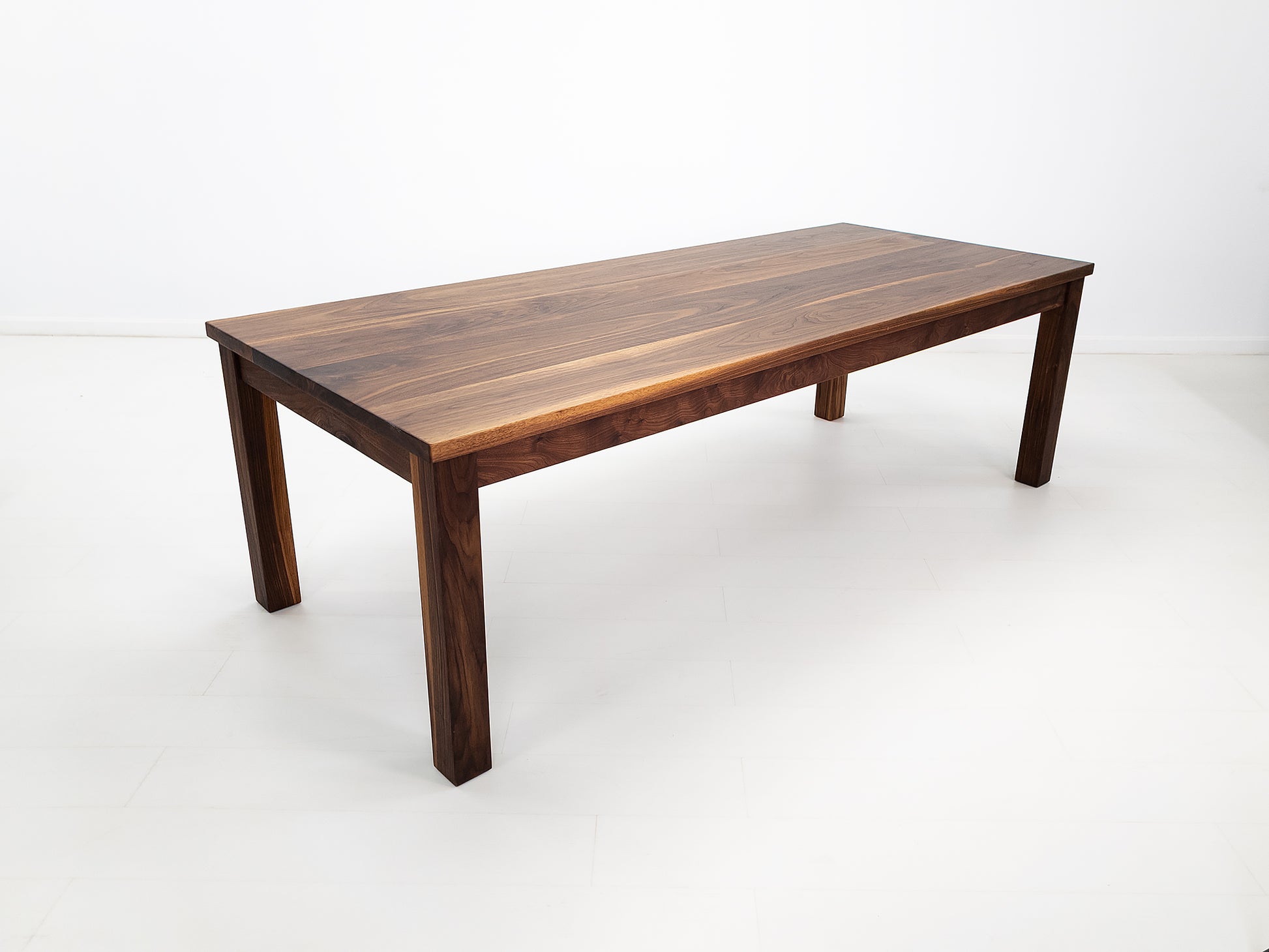 JONA dining table in oiled walnut with square legs.