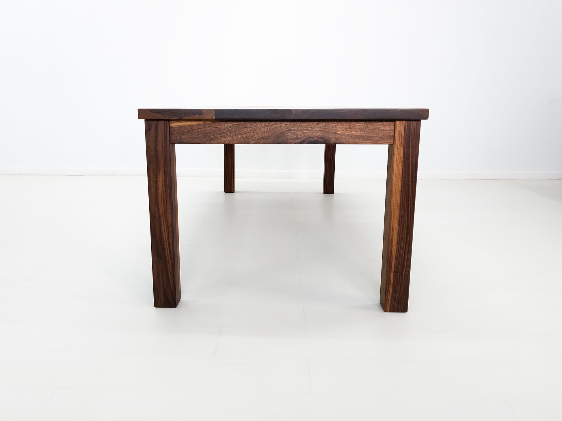 JONA dining table in oiled walnut with square legs.